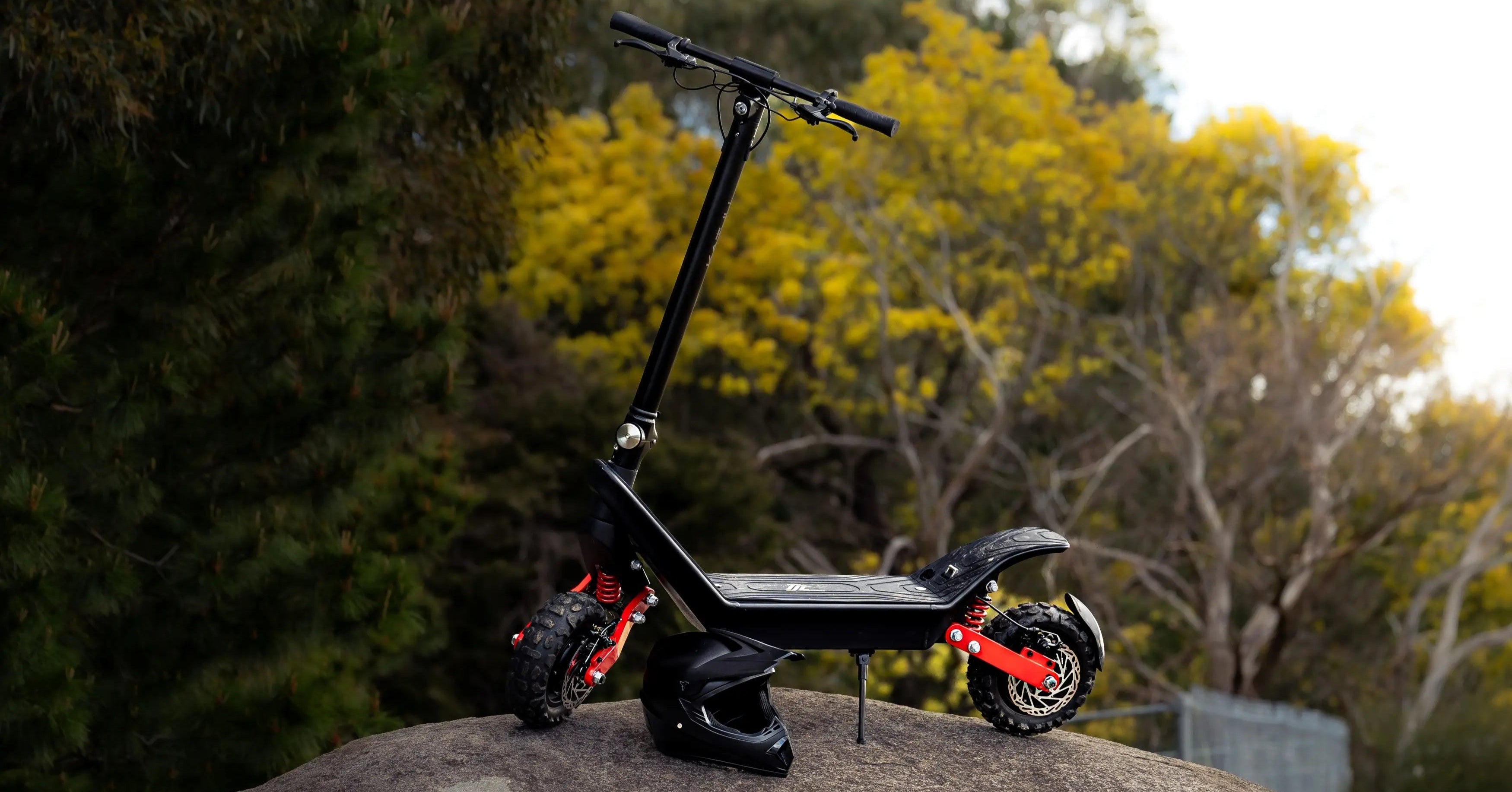 Black electric scooter on a rock with trees in the background
