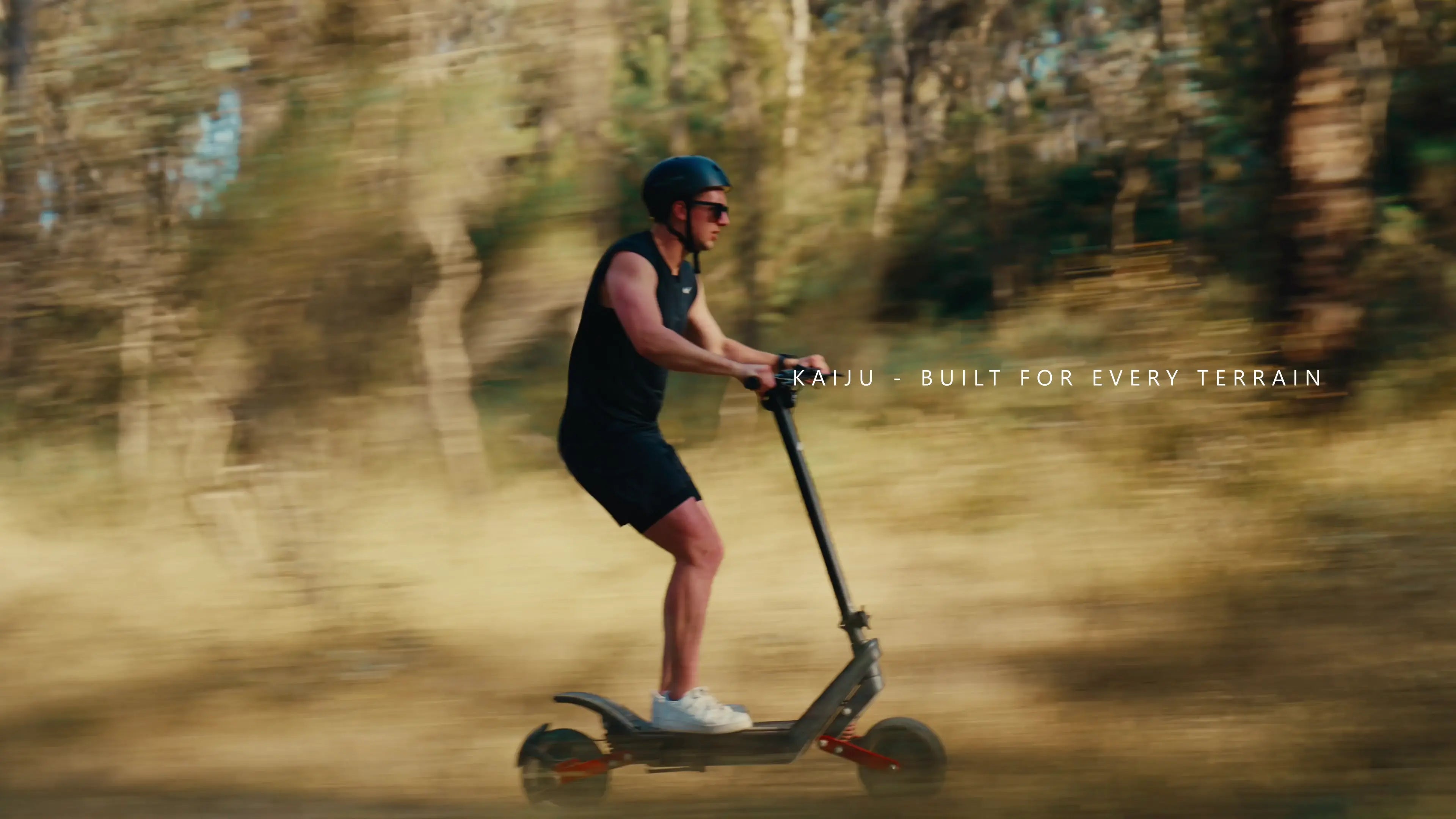 Person riding a scooter on a dirt path with a blurred background